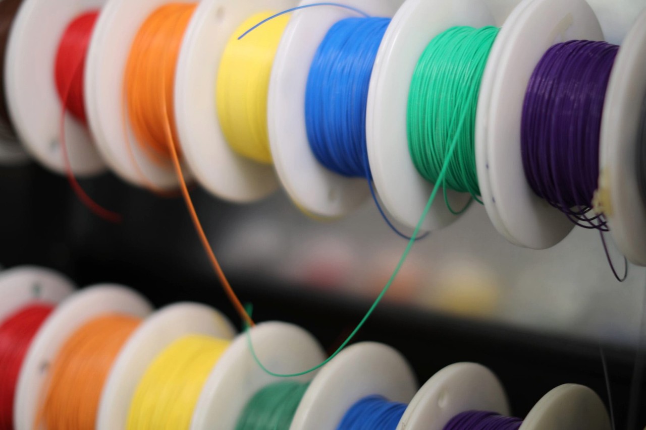 Spools of red, orange, yellow, blue, green, and violet thread.